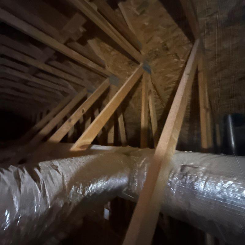 Ductwork installation in attic with wooden framing