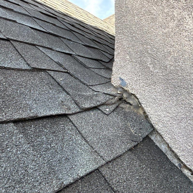 Roof shingles and flashing damage near chimney base