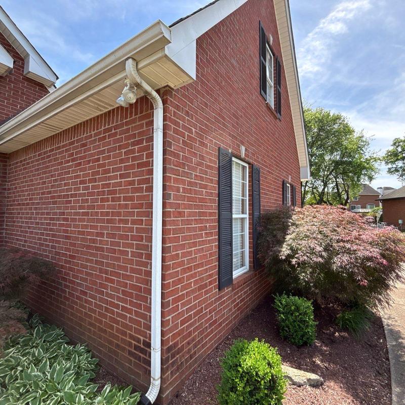 Gutter downspout and brick exterior with landscaping