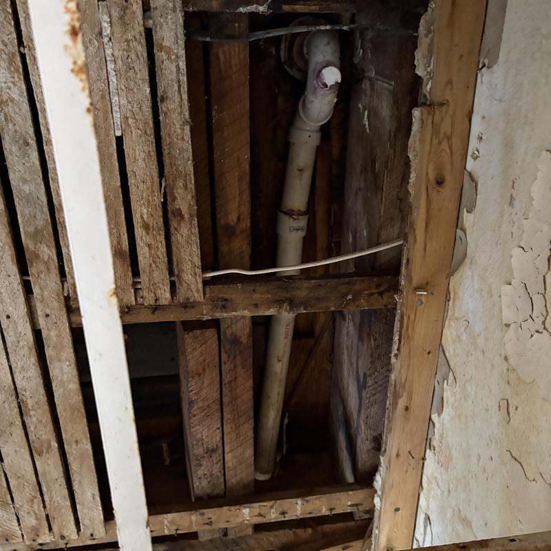 PVC shower drain pipe and plumbing in ceiling cavity
