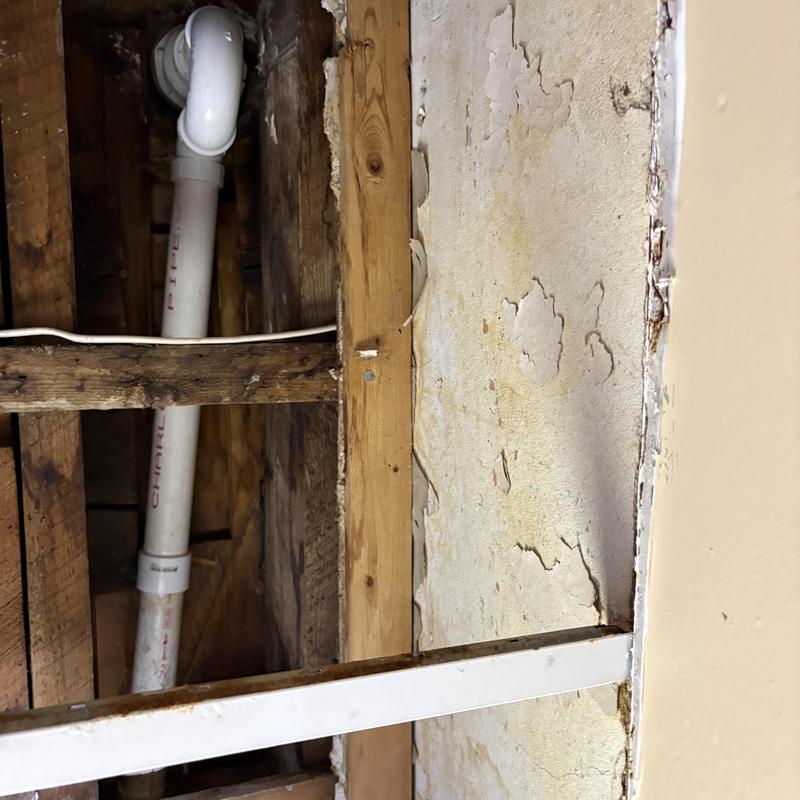 PVC shower drain pipe with elbow fitting in wall cavity