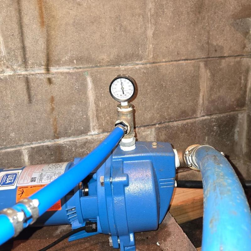 Pressure tank with gauge adjusted to 28 psi in basement