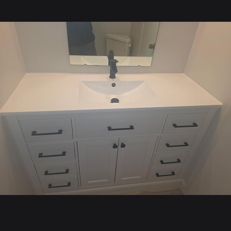 Vanity with black faucet and white countertop installation