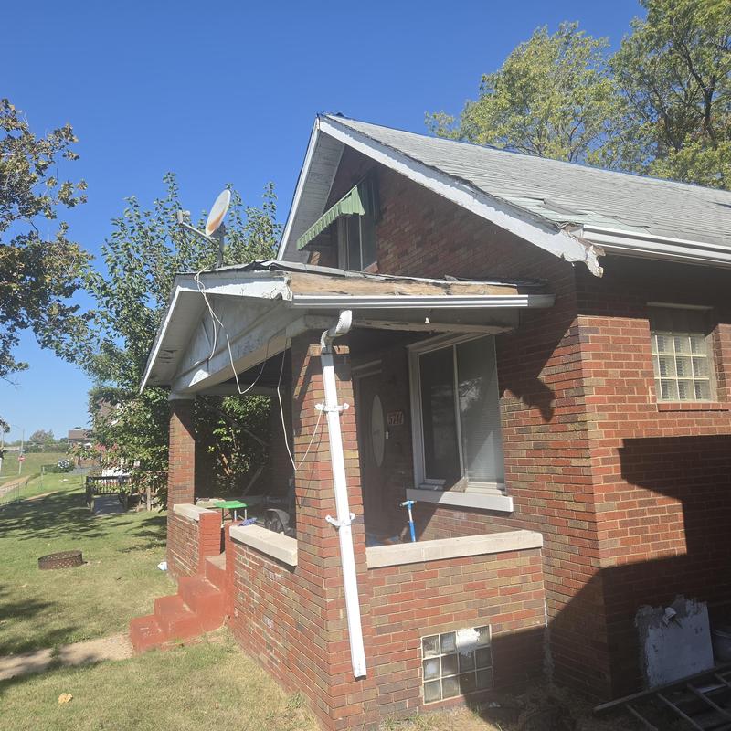 Porch roof decking and fascia board damage, brick home