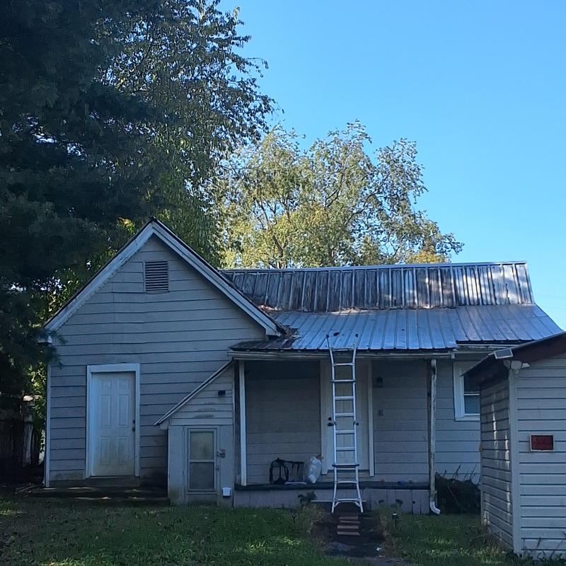 Metal roof with visible rust and damage near back door Metal roof with visible rust and damage near back door
