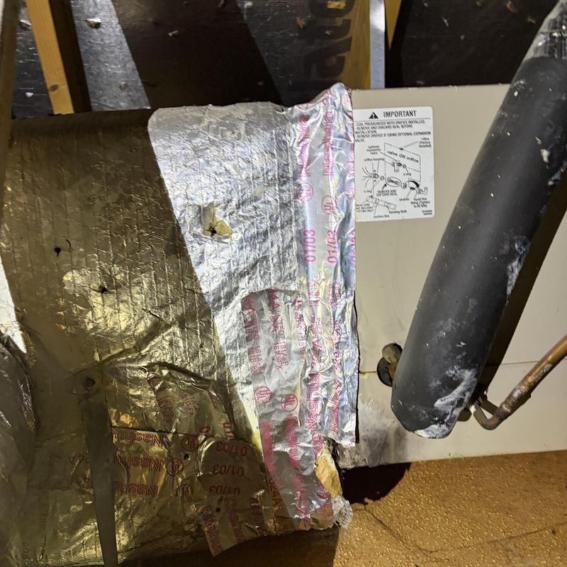 HVAC duct insulation with damaged reflective wrap