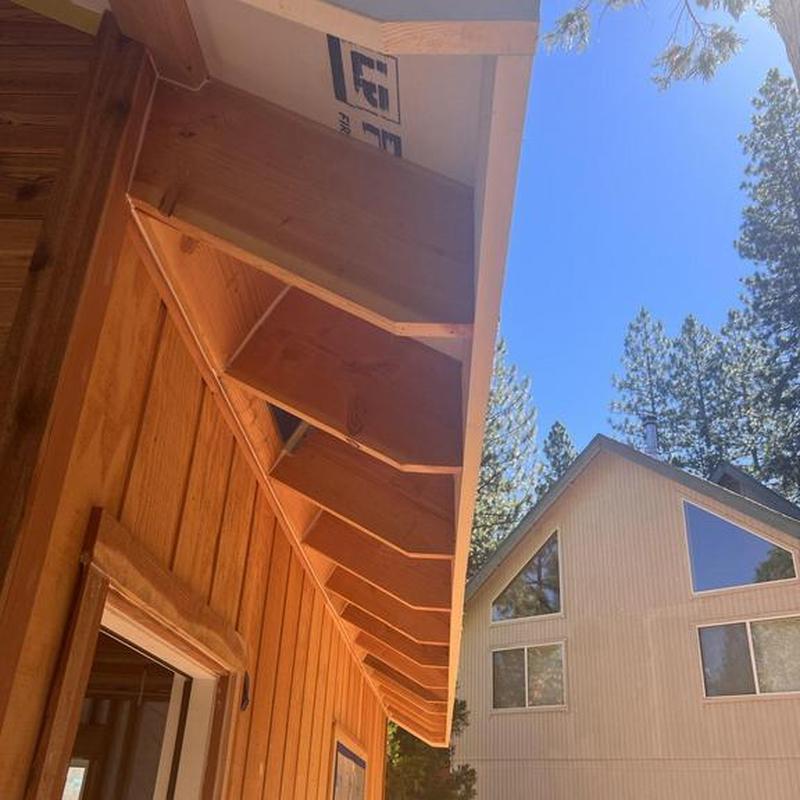 Cabin wooden eaves framing with new sheathing panels