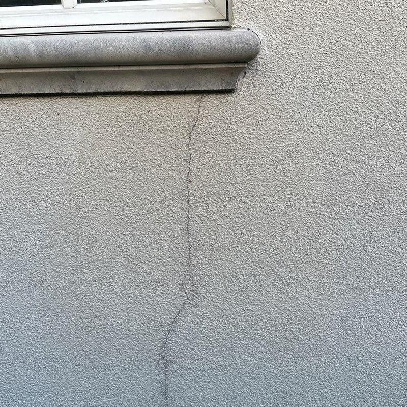 Stucco wall crack beneath exterior window ledge Stucco wall crack beneath exterior window ledge