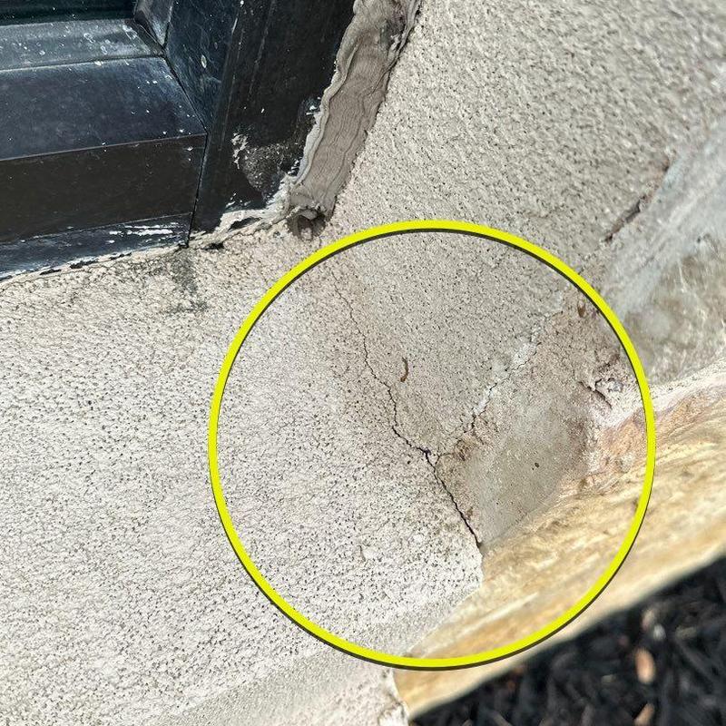 Stucco wall cracks near window frame with exposed mesh Stucco wall cracks near window frame with exposed mesh