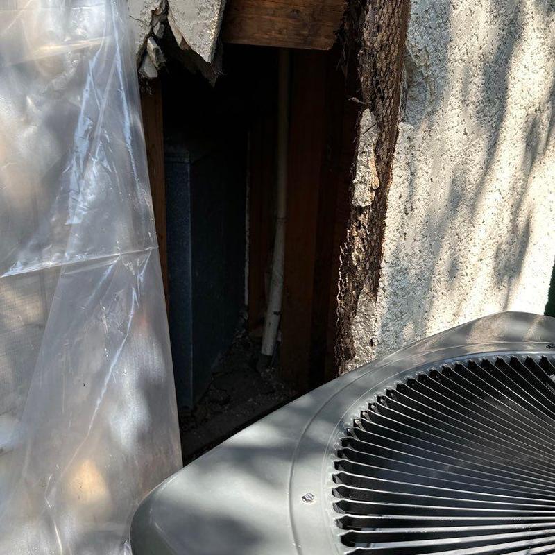 Stucco wall damage exposing framing next to AC unit Stucco wall damage exposing framing next to AC unit