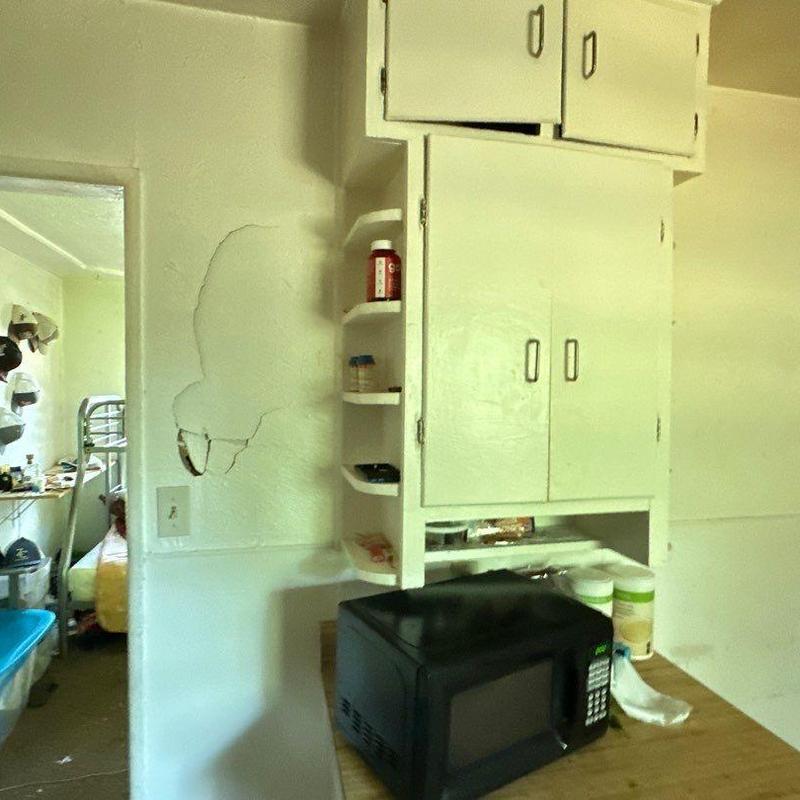Interior stucco wall with visible cracking near cabinetry Interior stucco wall with visible cracking near cabinetry