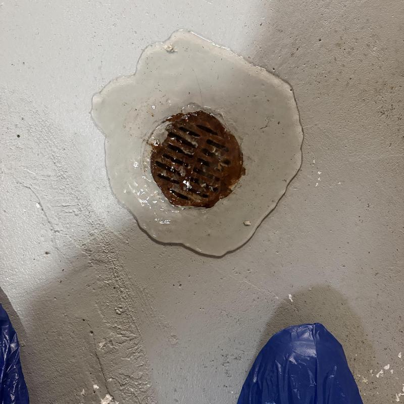 Main drain clogged with water pooling on concrete floor