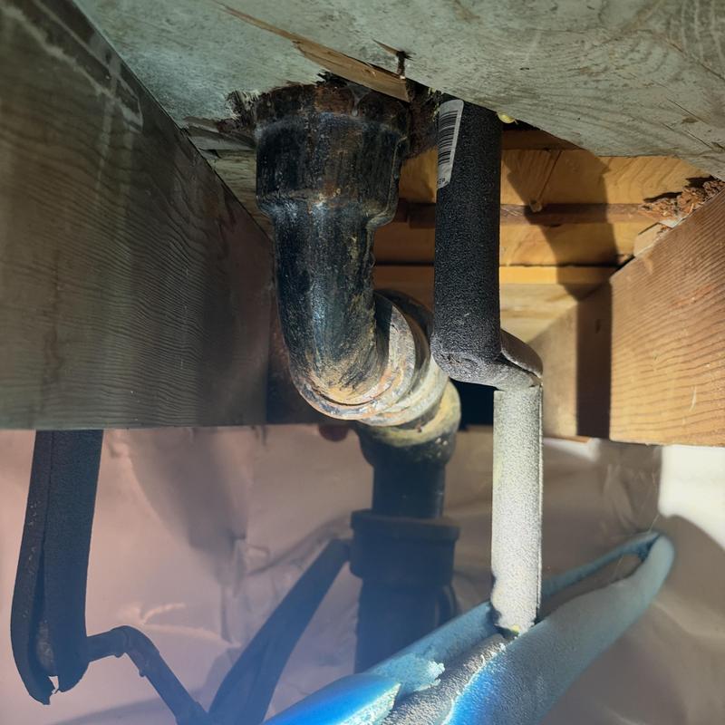 Cast iron drain pipe under floor joist with insulation foam