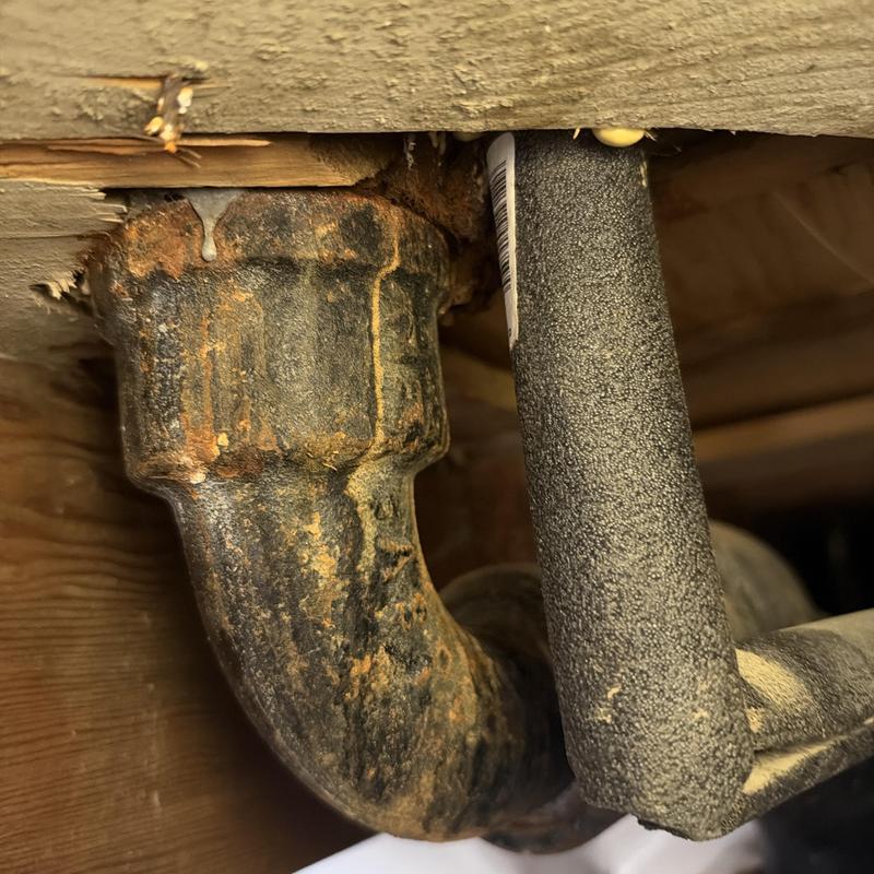 Corroded cast iron drain pipe under wood floor