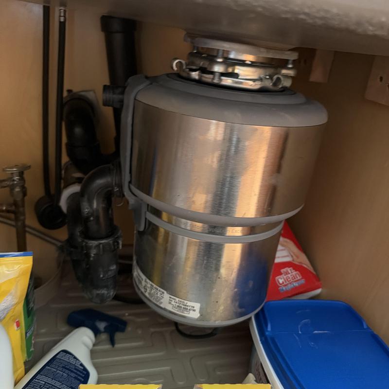 Garbage disposal unit under kitchen sink with pipes