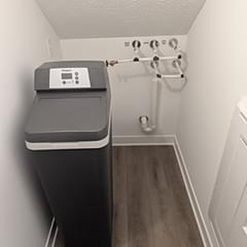 Water softener system with piping installation in laundry room