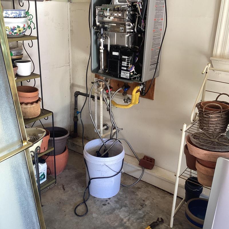 Tankless Rinnai water heater descaling setup in garage Tankless Rinnai water heater descaling setup in garage