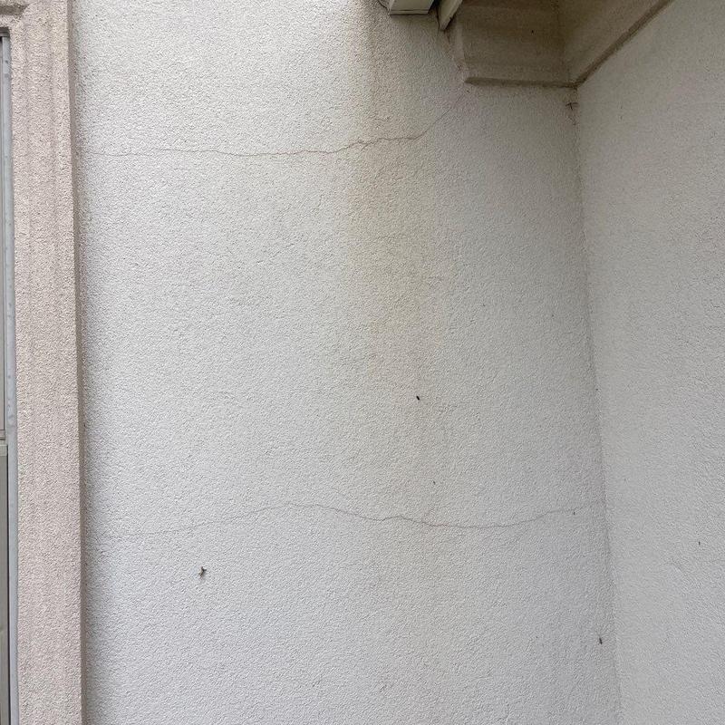 Stucco exterior wall with hairline cracks and stains Stucco exterior wall with hairline cracks and stains