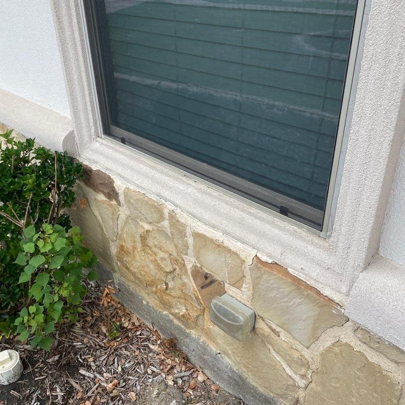 Stucco and stone veneer damage near window base Stucco and stone veneer damage near window base