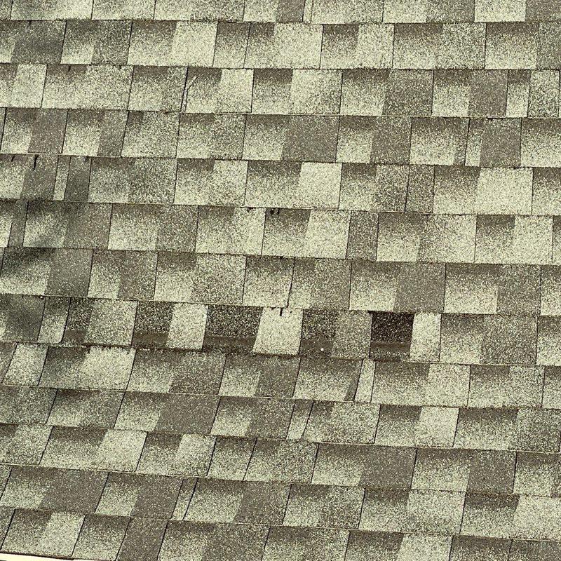 Roof shingles with wear and damage spots Roof shingles with wear and damage spots
