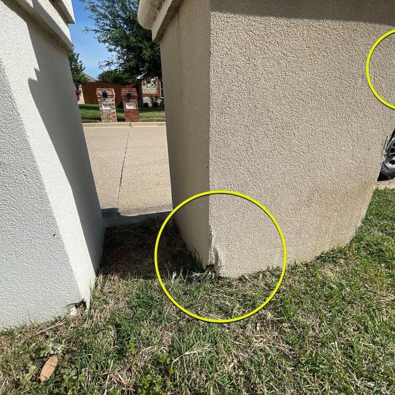 Stucco column cracks near base with damage marks Stucco column cracks near base with damage marks