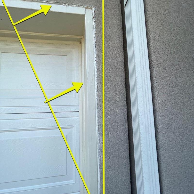 Stucco cracks around garage door trim with damage marks Stucco cracks around garage door trim with damage marks