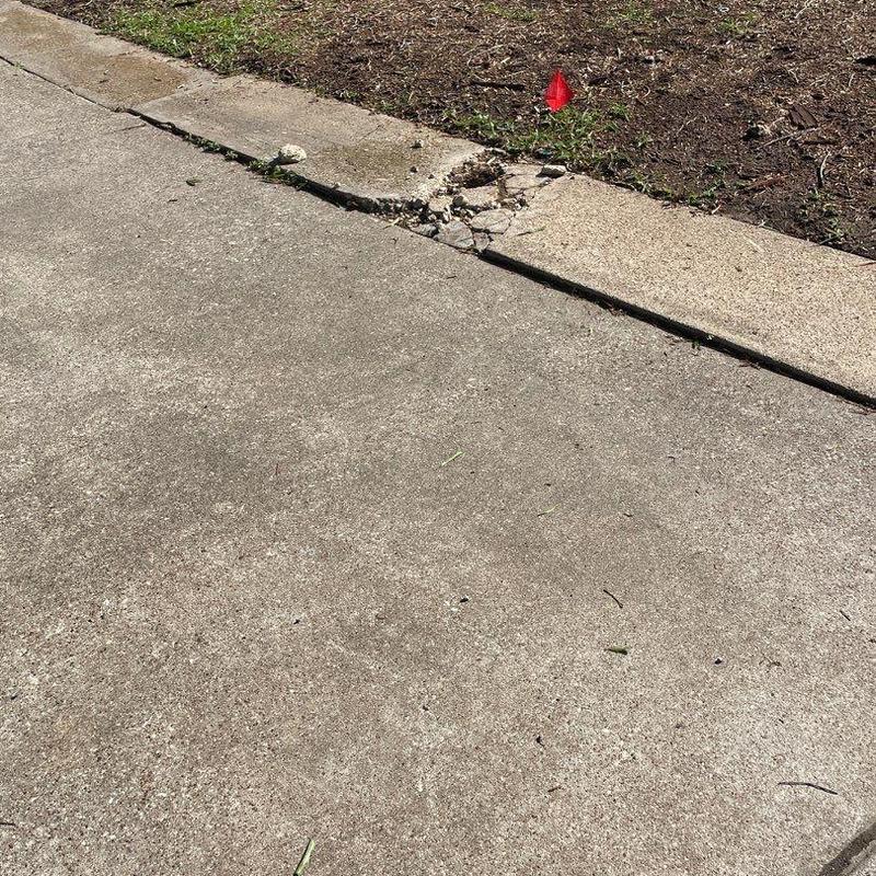 Concrete driveway edge with cracked and broken sections Concrete driveway edge with cracked and broken sections