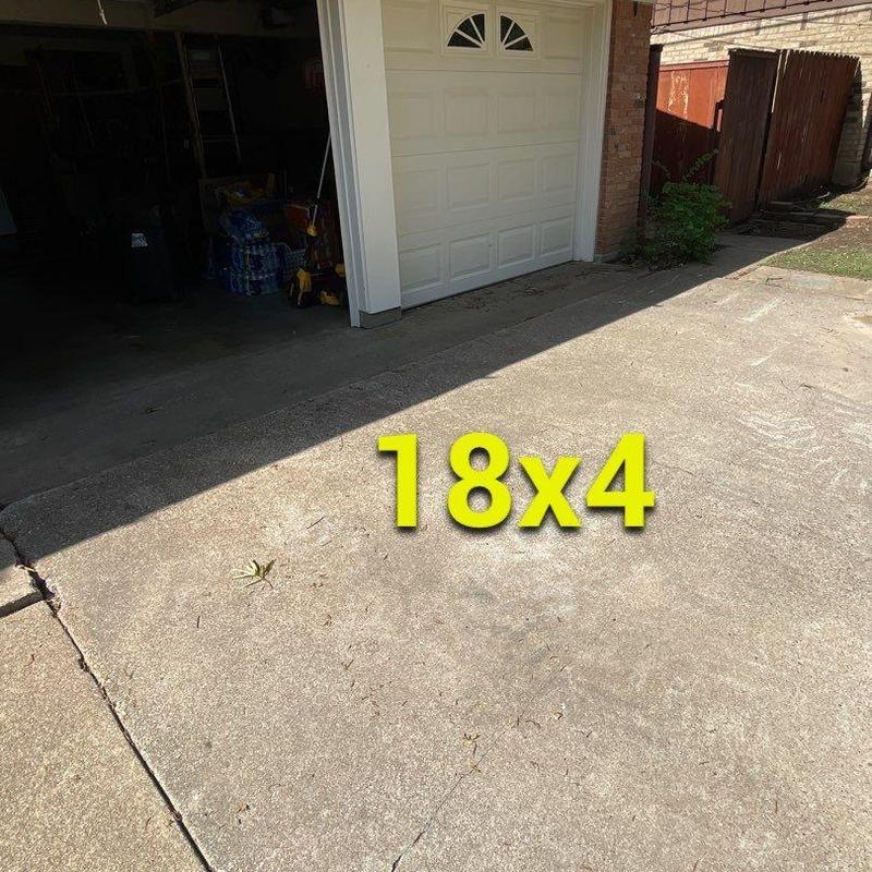 Concrete driveway with visible cracks near garage door Concrete driveway with visible cracks near garage door