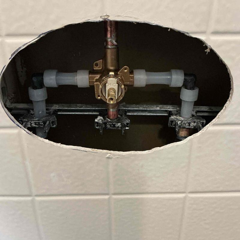 Shower valve with copper and PVC plumbing inside wall cavity