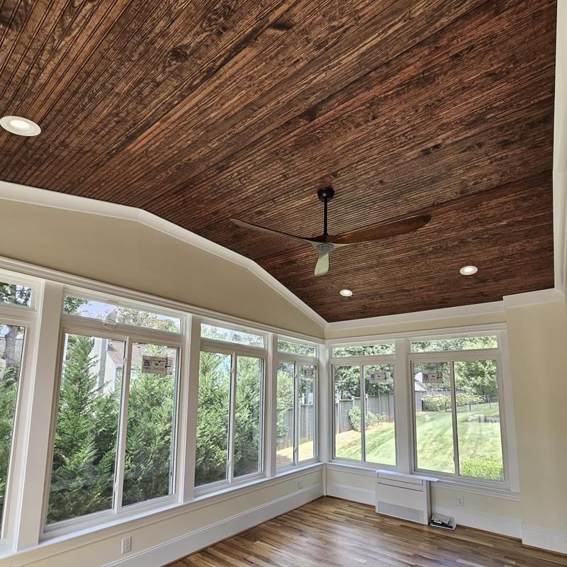 Sunroom with wooden plank ceiling and large windows