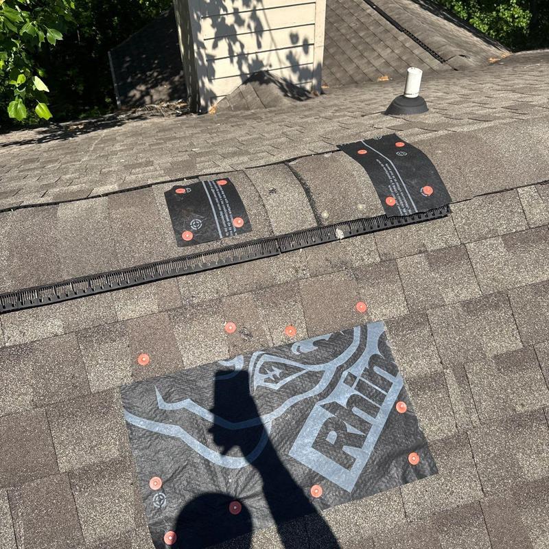 Asphalt shingle roof with hail damage repair patches