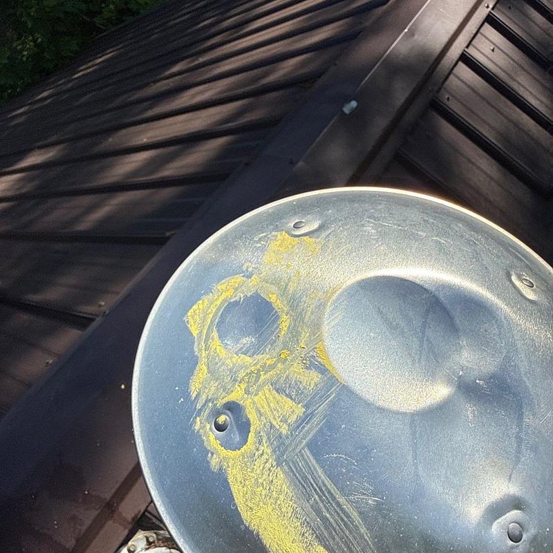 Metal roof vent with hail impact damage on residential roof