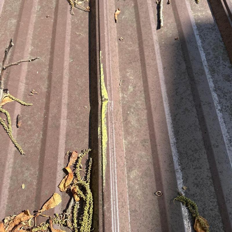 Metal roofing panel with dent and debris