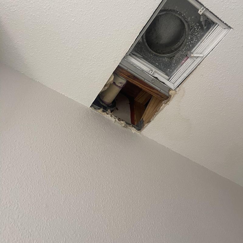 Ceiling plumbing pipes and vent duct exposed through access hole Ceiling plumbing pipes and vent duct exposed through access hole