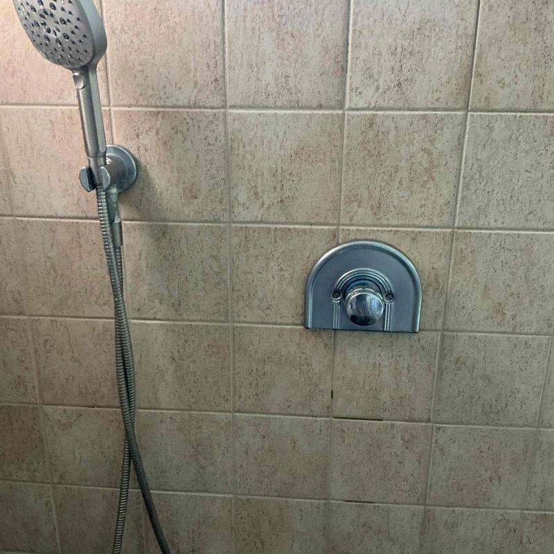 Shower head and arm installation on tiled wall