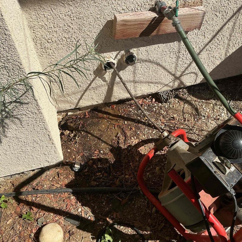 Kitchen drain line with snake clearing blockage outdoors