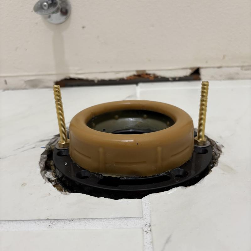 Toilet flange installation on tiled floor close-up