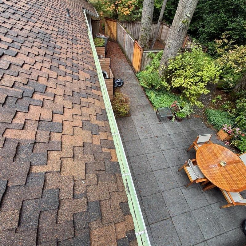 Gutter cleaning along residential roof edge
