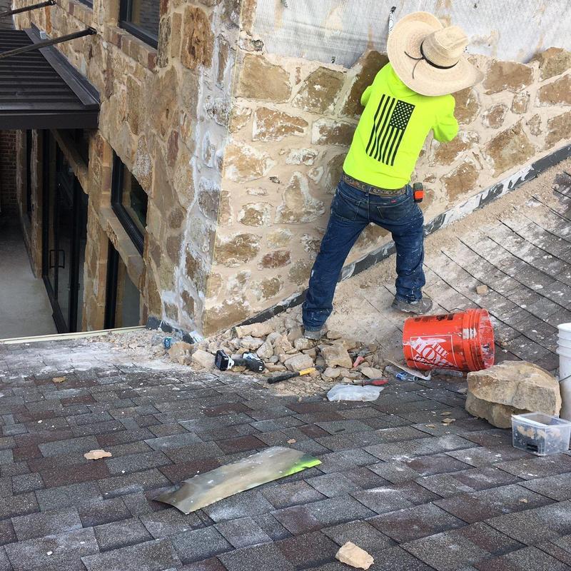 Stone veneer exterior wall installation with worker Stone veneer exterior wall installation with worker
