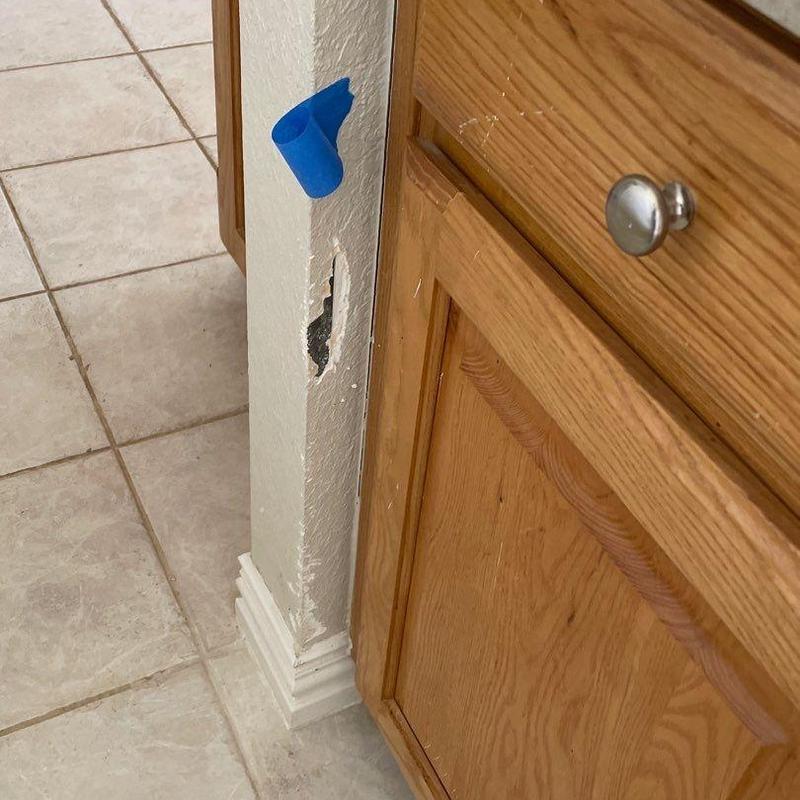 Stucco wall damage near kitchen cabinet base Stucco wall damage near kitchen cabinet base