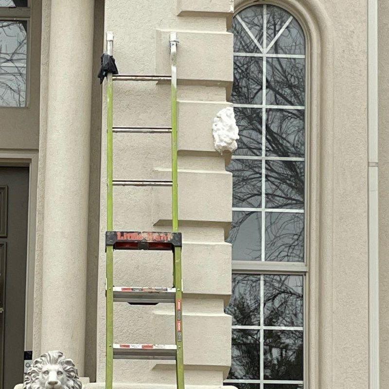 Stucco wall patching with ladder at Trophy Club home Stucco wall patching with ladder at Trophy Club home
