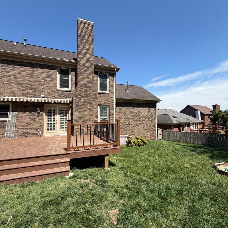Deck railing and brick chimney on residential backyard