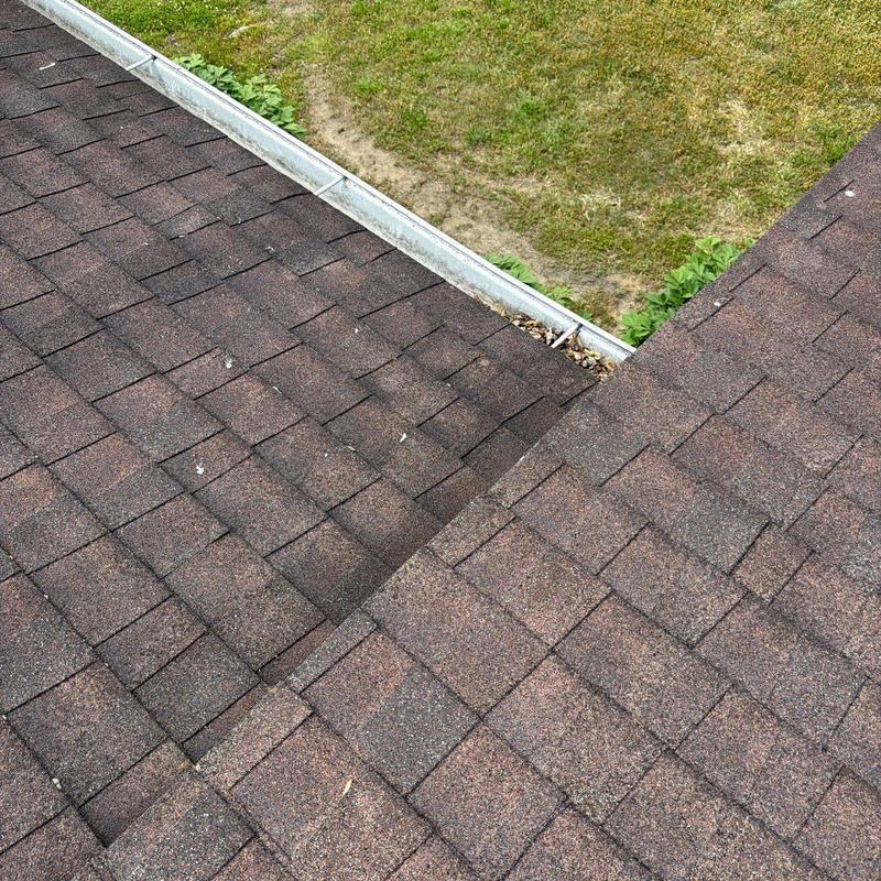 Asphalt shingle roof with metal gutter during inspection
