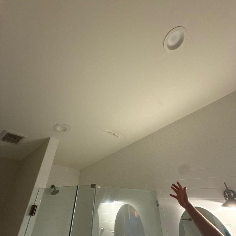 Bathroom ceiling with water damage above shower area