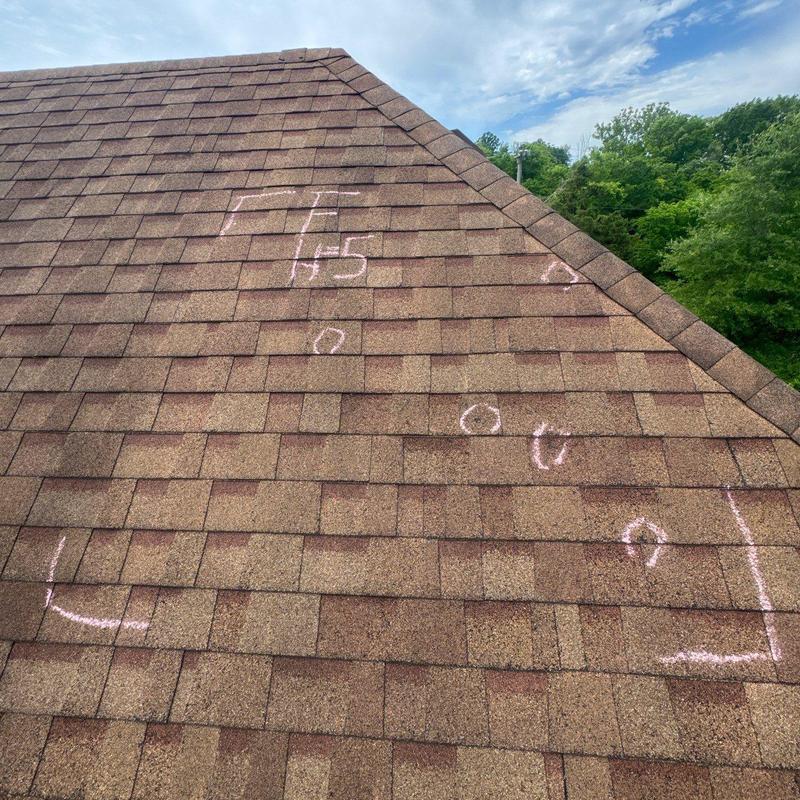 Asphalt shingles with hail impact markings on roof