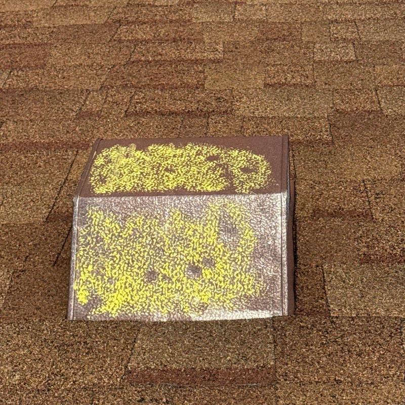 Roof vent with yellow hail damage markings on shingles