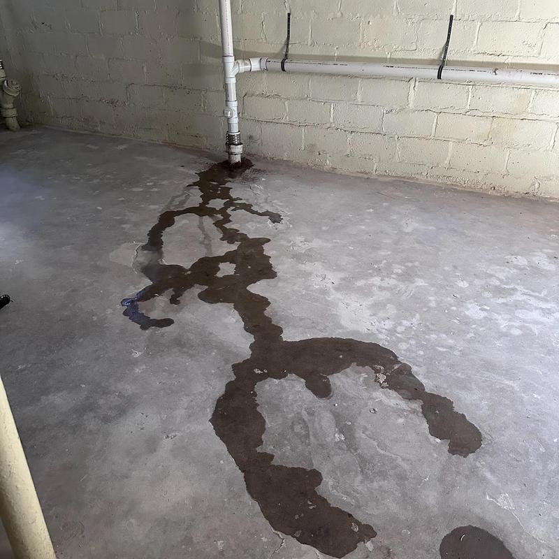 Main line sewer pipe leak with water on basement floor