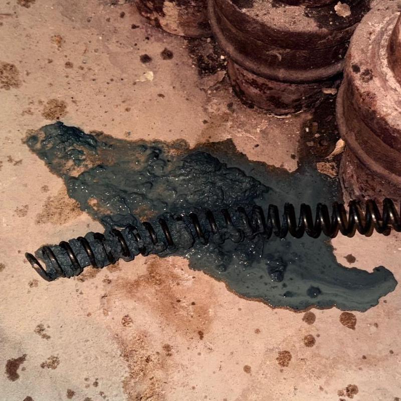 Main line sewer clog with plumbing snake and residue