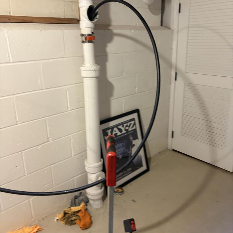 Drain cleaning jetter hose inside basement drain pipe
