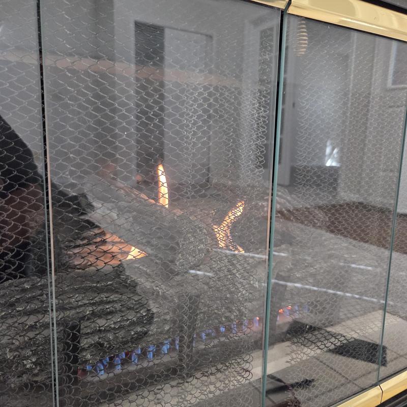 Gas fireplace flame behind protective mesh screen Gas fireplace flame behind protective mesh screen